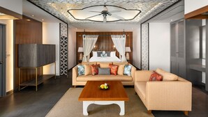 A modern hotel room with a large bed, a sofa, a coffee table, and a ceiling fan. - Dewa Phuket - Pool Villa (Sa Khu)