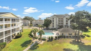 A multi-story hotel with a swimming pool and landscaped grounds. - Ocean Keyes 2242- 2BR/2BA-Close to Main St (North Myrtle Beach)