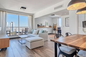 Enjoy a city view from the spacious balcony, featuring a comfortable seating area, dining space, and workspace.