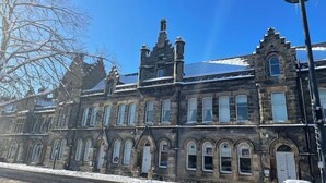 A historic building with arched windows and a stone facade.