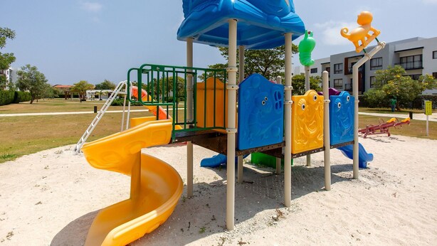 A playground with a slide, climbing structures, and a sandpit.