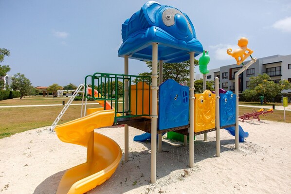 A playground with a slide, climbing structures, and a sandpit.