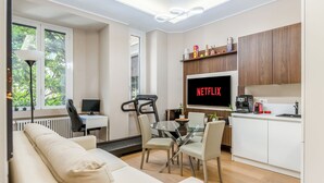 A modern living room with a sofa, a glass dining table, and a TV displaying 'NETFLIX'. - City Center Porta Venezia New Luxury apt - full equiped - top (Milano)