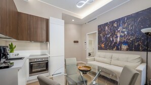 A modern kitchen with white cabinetry, a built-in oven, and a glass dining table with chairs. - City Center Porta Venezia New Luxury apt - full equiped - top (Milano)
