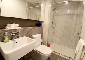 A bathroom with a sink, toilet, and glass-enclosed shower. - 2x 2BR Apartment on Rose Lane (Melbourne)