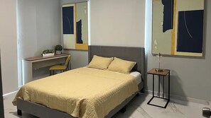 Une chambre à coucher avec un lit, un bureau et une chaise.