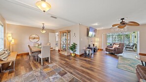 Relax in this spacious living area with a dining table, comfortable sofa, and large armchair.