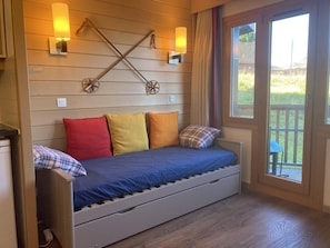 A compact room with a bed, wooden panel walls, and two wall-mounted lights. - 10m from ski slopes, 1st floor, balcony, tv, 22m², Avoriaz (Avoriaz)