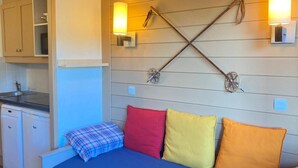 Una camera da letto con un letto, cuscini, un punto luce a parete e un pannello decorativo in legno.