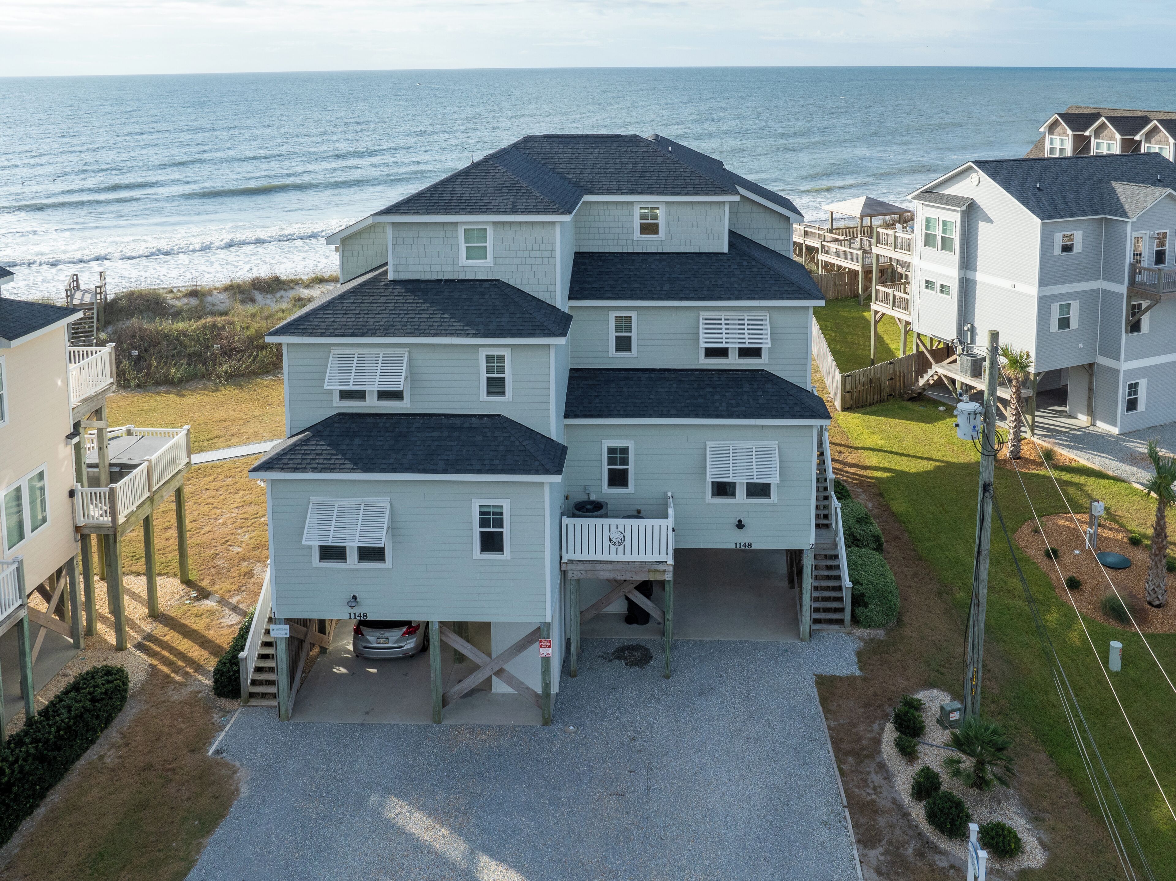 A multi-story beachfront property with a covered driveway and a visible garage.