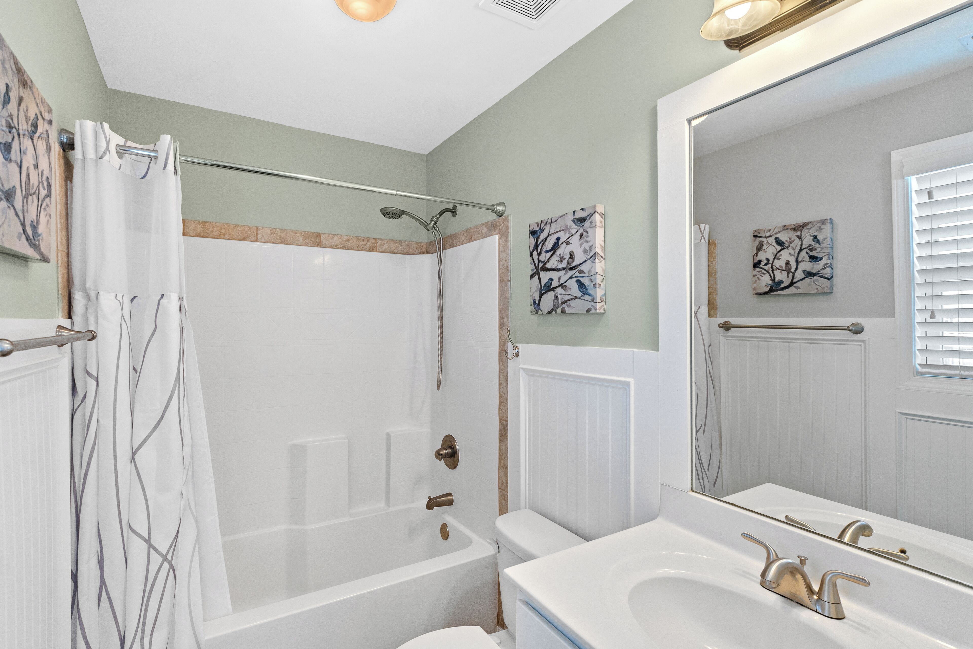 A bathroom with a bathtub, toilet, and sink.