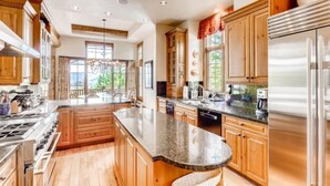 A spacious kitchen with wooden cabinets, granite countertops, and stainless steel appliances.