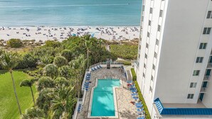 Ein Hotel mit Pool, Blick auf den Strand und einem Hochhaus.