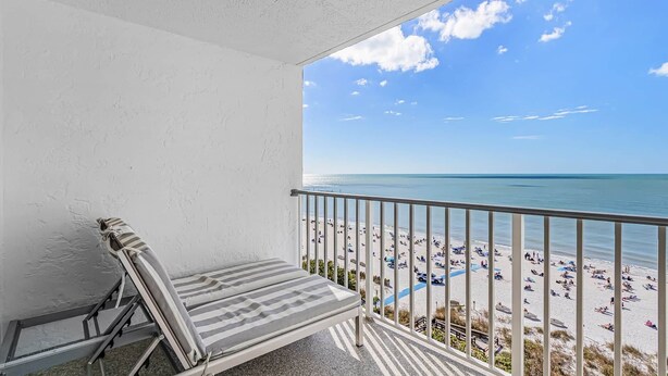 Ein Balkon mit Blick auf Strand und Meer.