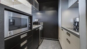 Cocina moderna con microondas, cafetera y lavavajillas integrados.