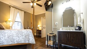A bedroom with a bed, a ceiling fan, a bedside table, and a nightstand. - Find genuine southern hospitality in Hendersonville at the 1898 Waverly Inn. (Hendersonville)