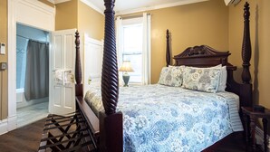 A bedroom with a four-poster bed, a wooden headboard, and a patterned bedspread. - Find genuine southern hospitality in Hendersonville at the 1898 Waverly Inn. (Hendersonville)
