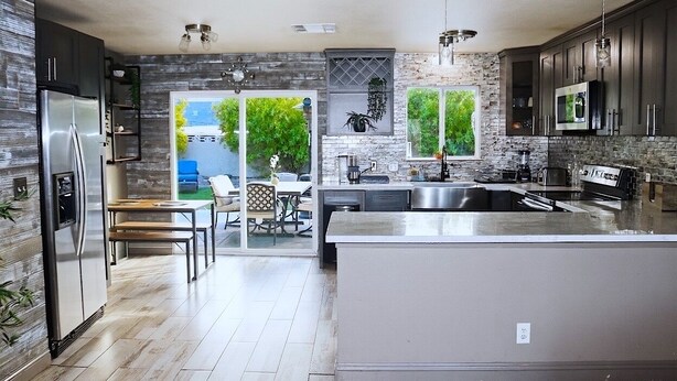 A modern kitchen with a large island, stainless steel appliances, and a view to the outdoors. - Charming 2-bedroom house in fantastic Las Vegas with AC, WiFi Casita los Hermano (Las Vegas)