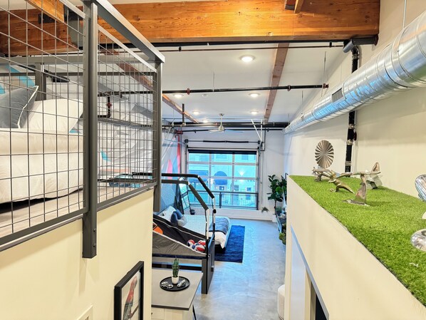 A modern interior with a bunk bed, a staircase, and a view of the outside.