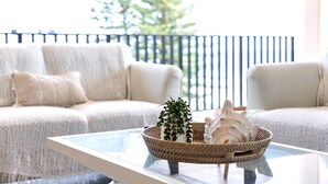 A living room with a sofa, a glass coffee table, and a wicker basket with decorative items. - Ocean Views Palm Beach (Palm Beach)