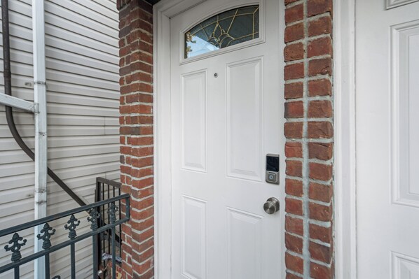 A white door with a small window above it, a metal mail slot, and a brick wall. - Spacious 4-bedroom apartment with WiFi, AC in enjoyable Newark (newark)