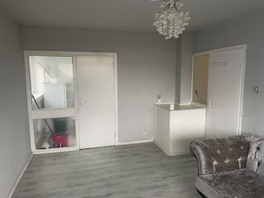 Relax in this serene space with a tufted leather sofa and a large mirror.