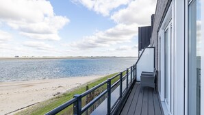 Un balcon avec vue sur une plage et la mer.