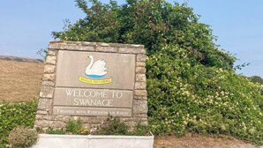 A welcome sign for Swanage, featuring a swan logo and text welcoming visitors to Swanage, twinned with Rudesheim am Rhein. - 1 bedroom accommodation in Swanage (Swanage)