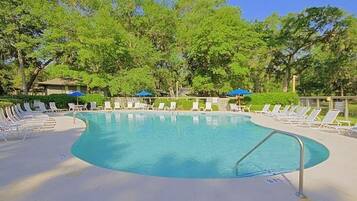 A swimming pool with lounge chairs and umbrellas.