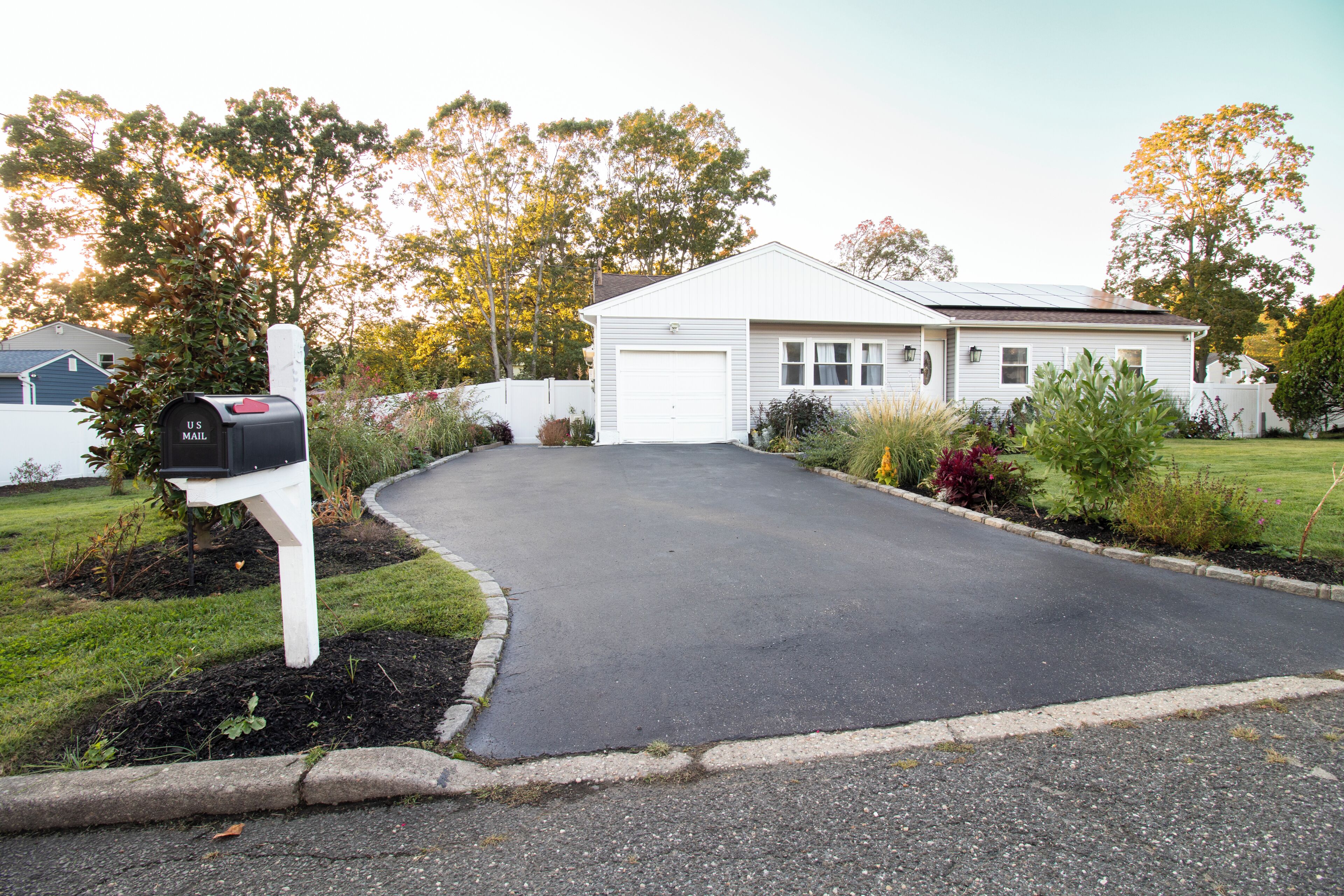 A residential driveway leading to a house with a mailbox.