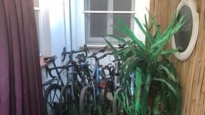 Un sendero de madera estrecho que conduce a un área de almacenamiento para bicicletas con varias bicicletas.