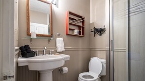 A bathroom with a sink, toilet, and a glass shower enclosure. - Find genuine southern hospitality in Hendersonville at the 1898 Waverly Inn. (Hendersonville)