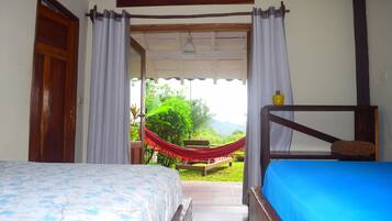 A bedroom with a bed, a wooden bench, and a hammock.