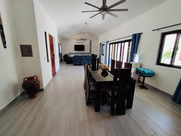 A spacious hallway with a dining area, a kitchen, and a living room.