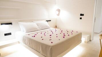 Een moderne slaapkamer met een groot bed, witte wanden en een minimalistisch design.