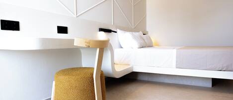 A modern bedroom with a built-in bed, a small round stool, and a bedside table with a lamp.