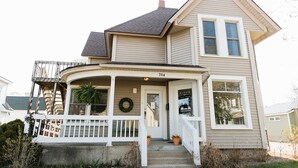 A two-story house with a porch, a front door, and a number 704 sign.