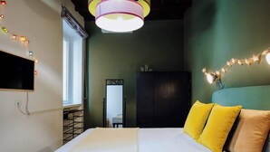 A bedroom with a bed, a TV mounted on the wall, a wardrobe, and a window. - Navona Boutique Apartment with terrace (Rome)