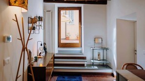 A modern interior with a staircase leading to a balcony, a wooden ceiling, and a minimalist decor. - Navona Boutique Apartment with terrace (Rome)