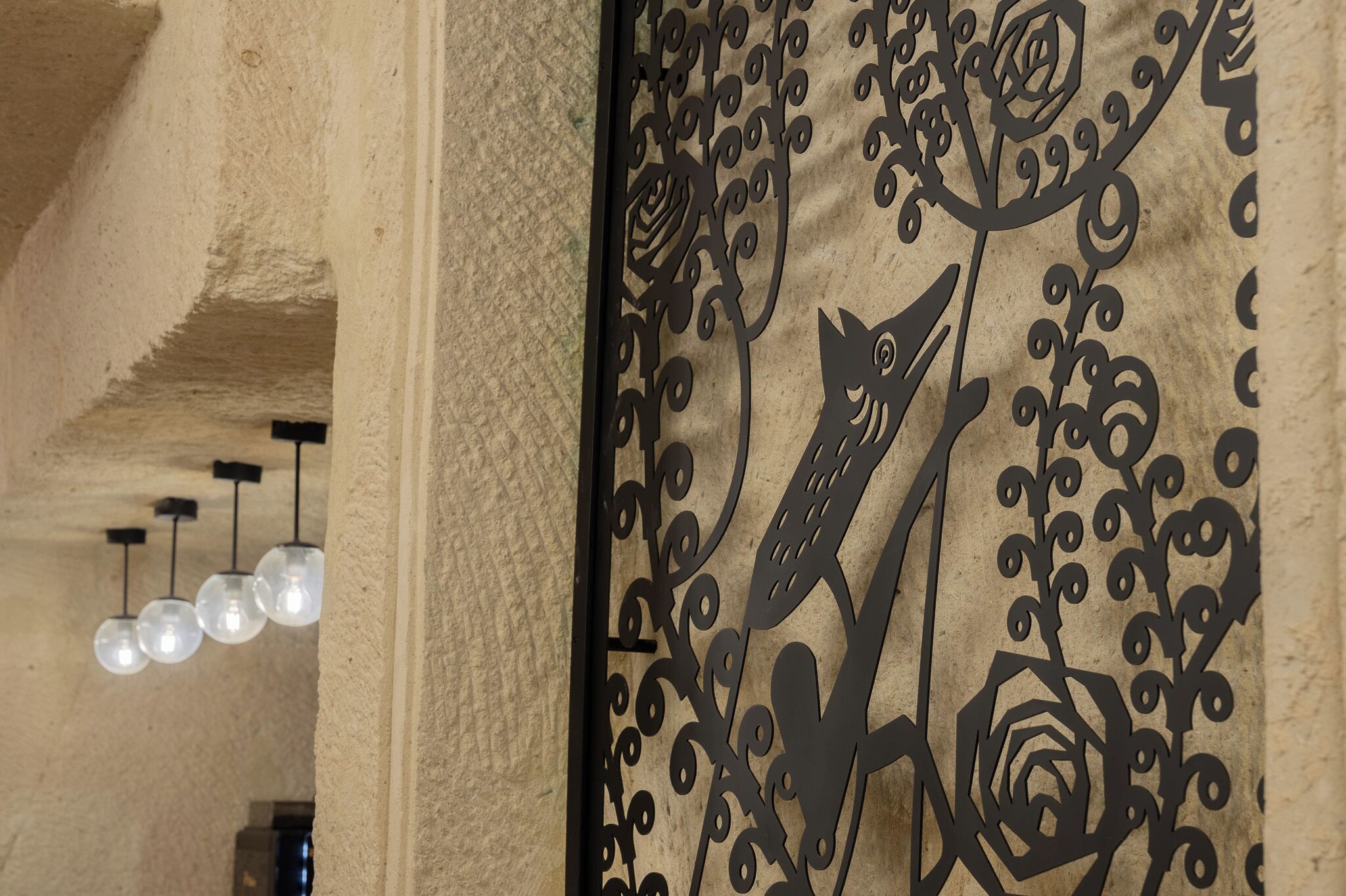 Een decoratief metalen paneel met ingewikkelde bloem- en dierdetails.