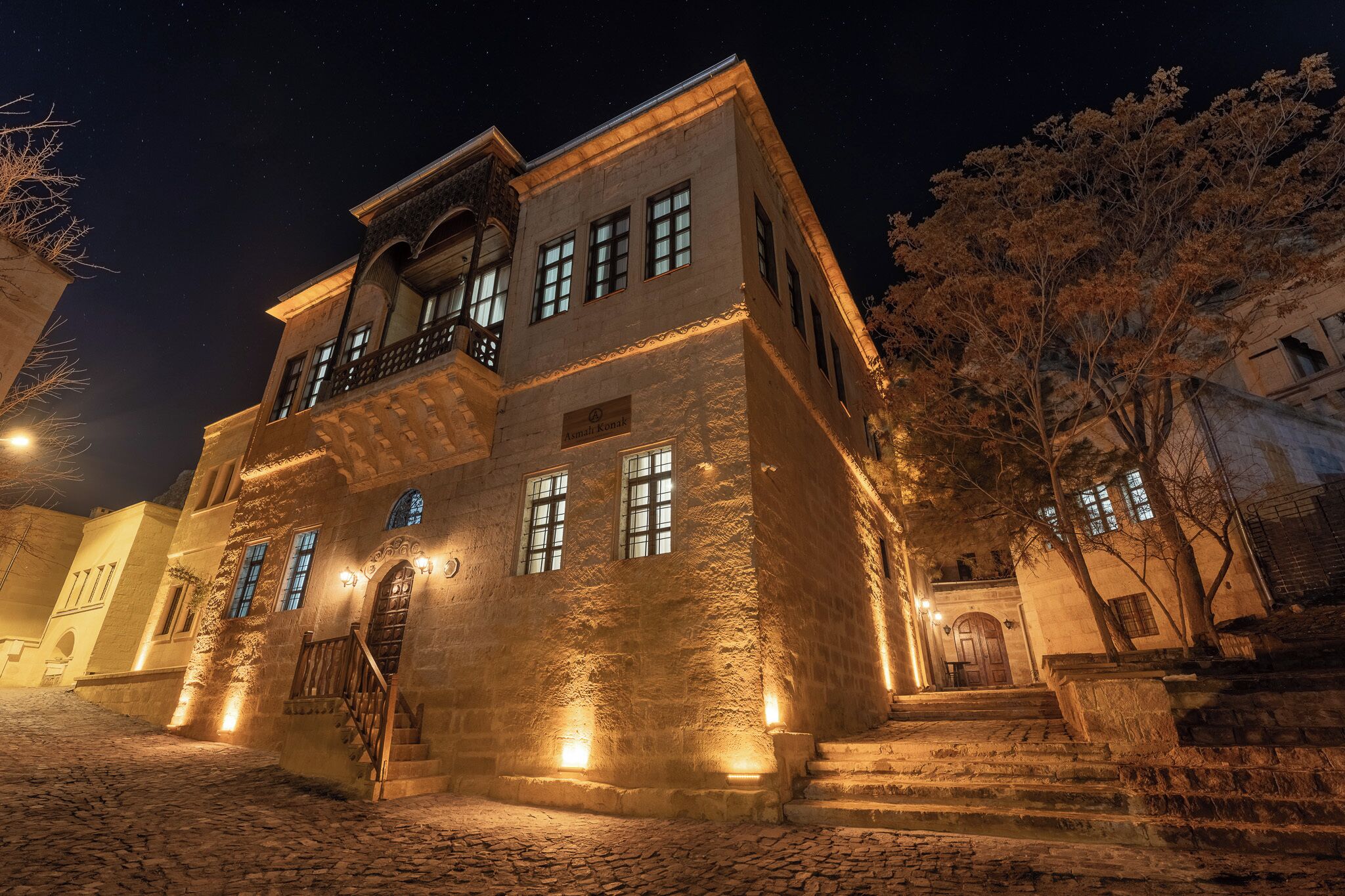 A historic building with a stone facade, multiple windows, and a balcony.