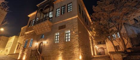 A historic building with a stone facade, multiple windows, and a balcony.