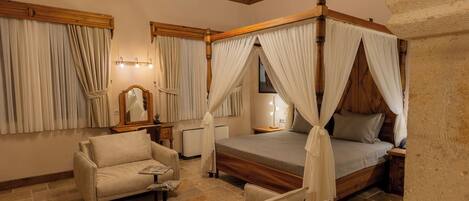 Une chambre à coucher avec un lit à baldaquin, un canapé, une table de chevet et une lampe.