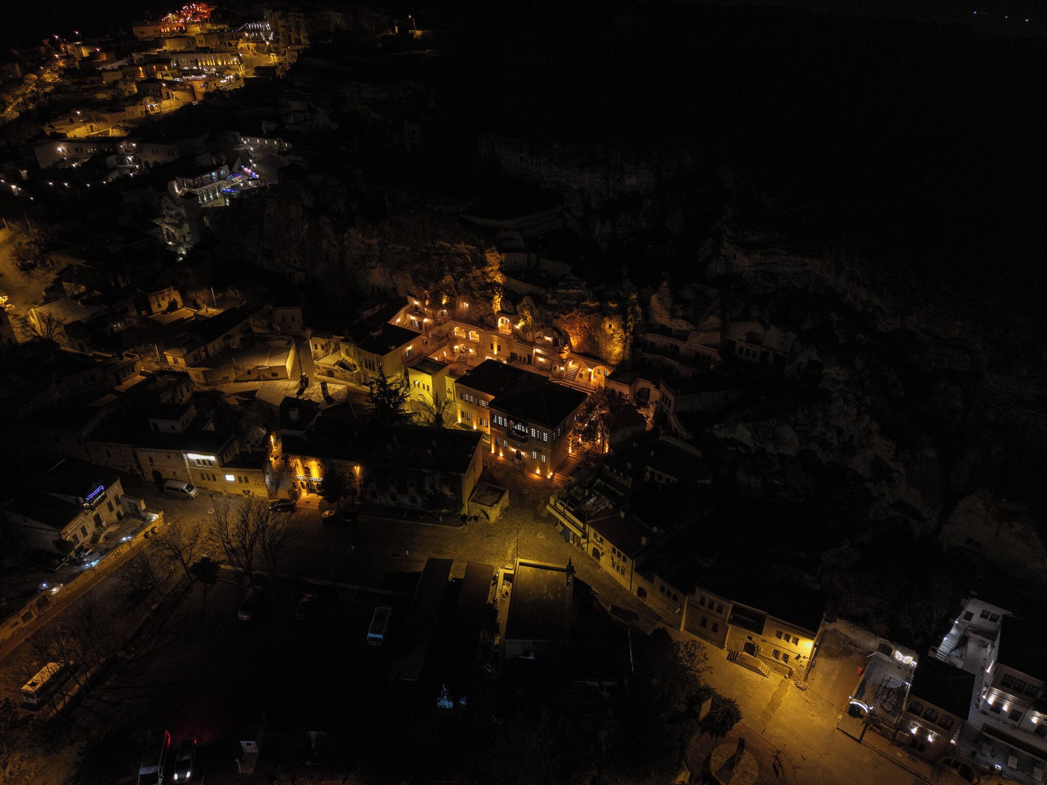 Vista aérea de un pueblo de noche, con edificios e iluminadas calles.