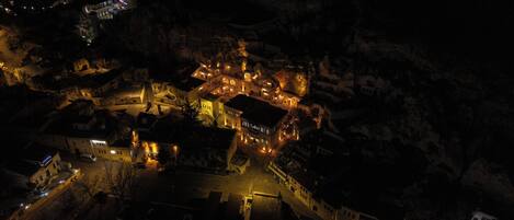 Vista aérea de un pueblo de noche, con edificios e iluminadas calles.