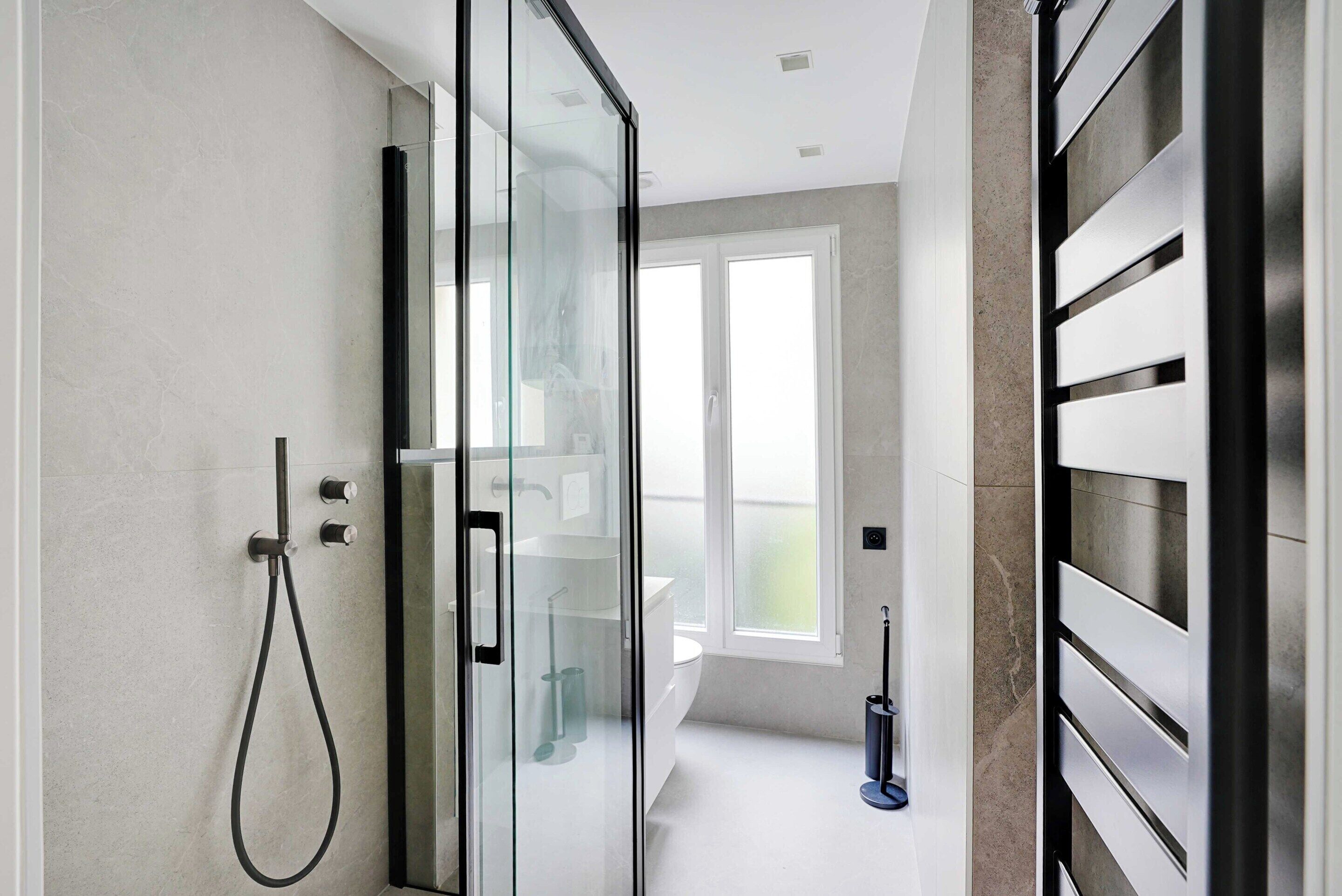 Un bagno moderno con box doccia in vetro, un water e un bidet.