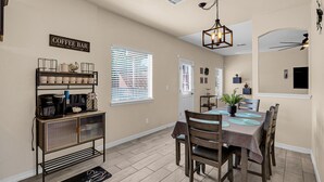 A dining area with a coffee bar, a chandelier, and a dining table set for six. - Huge Oasis Retreat>Arcade>Pool Table>Heated Pool & Spa>Super H on AirBB (El Paso)