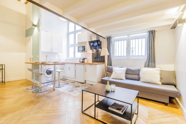 Eine moderne Wohnung mit einer Küchenzeile, einem Sofa und einem Essbereich.
