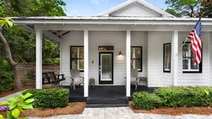 A white house with a porch, a black front door, and an American flag. - Pools*Bikes*Pools*Walk2beach (Santa Rosa Beach)