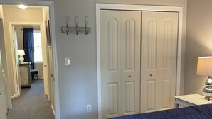 A bedroom with a large bed, a desk with a lamp, and a wardrobe. - Down Home Comfort - Greenville, SC

 (Piedmont)